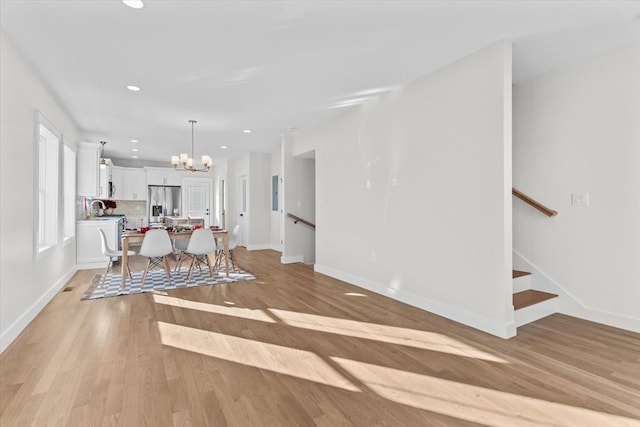 dining room featuring light wood-type flooring and an inviting chandelier