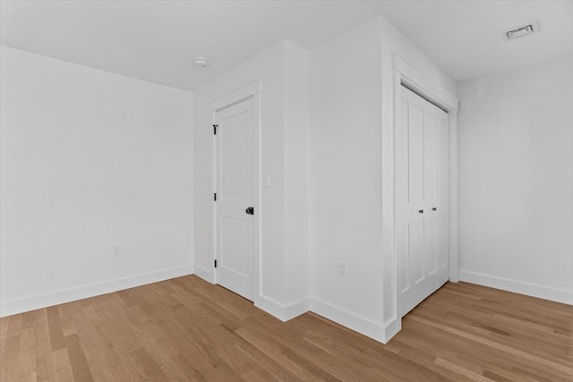 unfurnished bedroom with a closet and light hardwood / wood-style floors