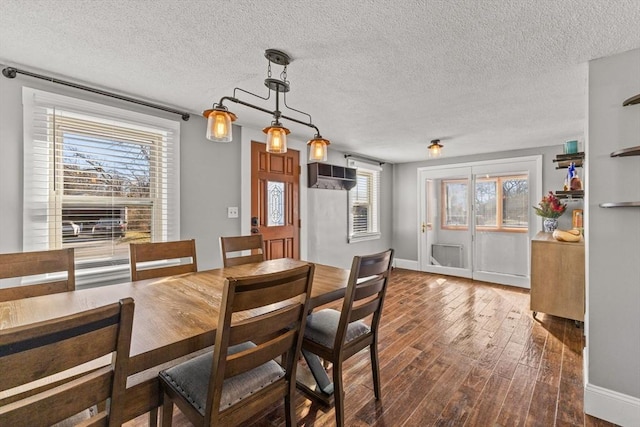 dining space with a textured ceiling, dark hardwood / wood-style floors, and a wealth of natural light