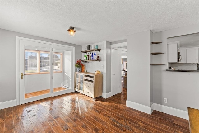 interior space featuring a textured ceiling and dark hardwood / wood-style flooring