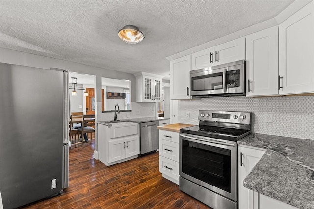 kitchen featuring decorative backsplash, appliances with stainless steel finishes, dark hardwood / wood-style flooring, sink, and white cabinets