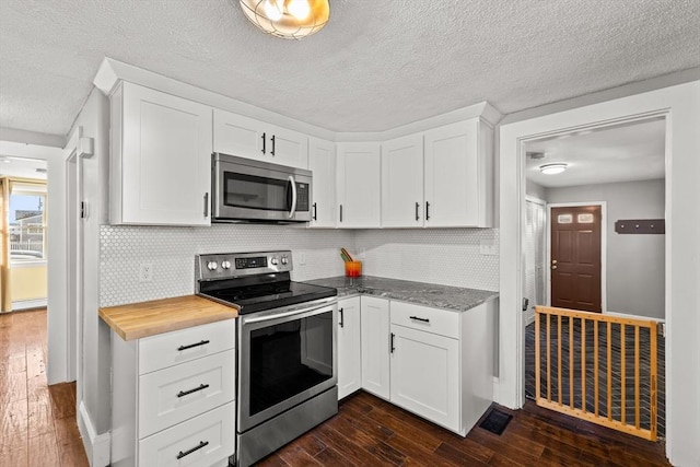 kitchen featuring backsplash, dark hardwood / wood-style flooring, white cabinetry, and stainless steel appliances