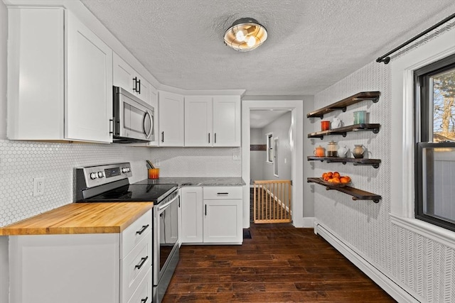 kitchen with wooden counters, a baseboard heating unit, dark hardwood / wood-style floors, white cabinetry, and stainless steel appliances