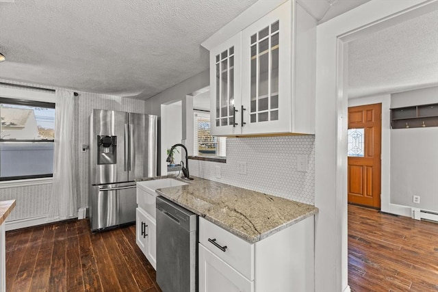 kitchen with tasteful backsplash, light stone counters, white cabinets, and stainless steel appliances