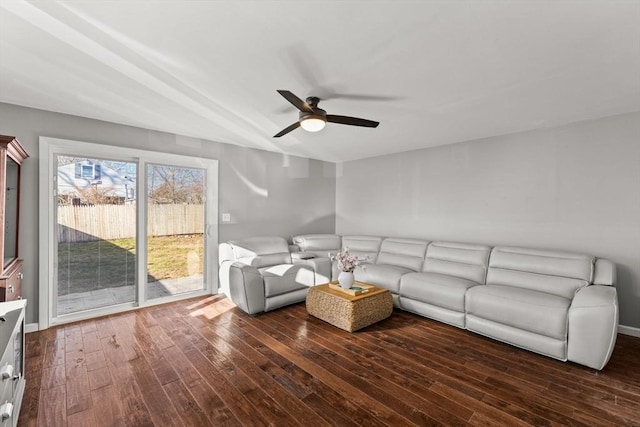 living room featuring ceiling fan and dark wood-type flooring