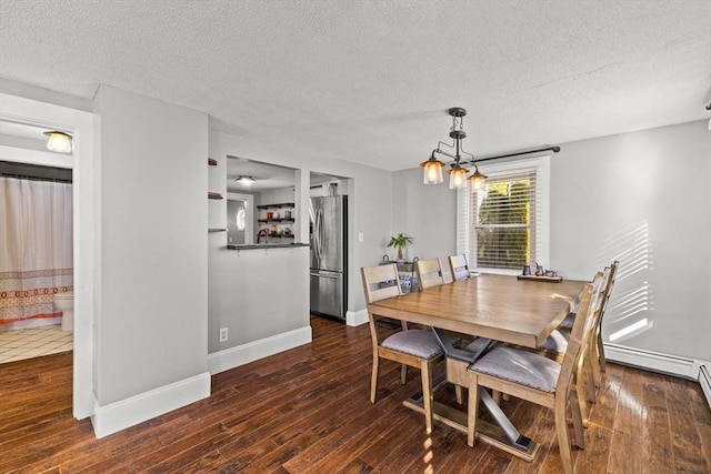 dining room featuring dark hardwood / wood-style floors, a textured ceiling, and an inviting chandelier