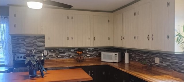 kitchen with backsplash, ceiling fan, and white cabinets