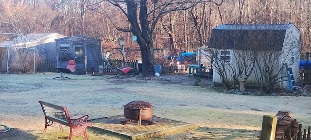 view of yard featuring an outdoor fire pit and a storage unit