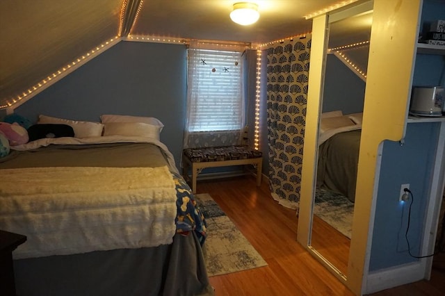 bedroom featuring hardwood / wood-style floors and vaulted ceiling