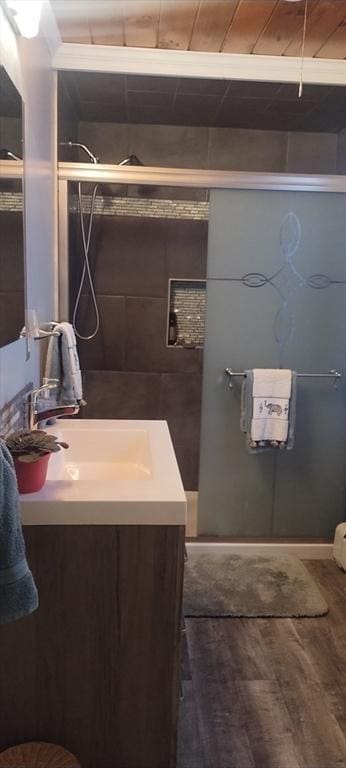 bathroom with hardwood / wood-style flooring, vanity, and a shower with shower door