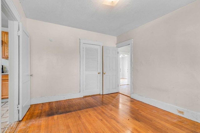 127-129 Blue Hills Pkwy, Milton, MA 02186 - unfurnished bedroom with light wood-style floors and a closet