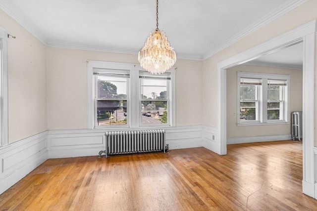 127-129 Blue Hills Pkwy, Milton, MA 02186 - unfurnished dining area with radiator heating unit, a chandelier, light wood-type flooring, crown molding, and wainscoting