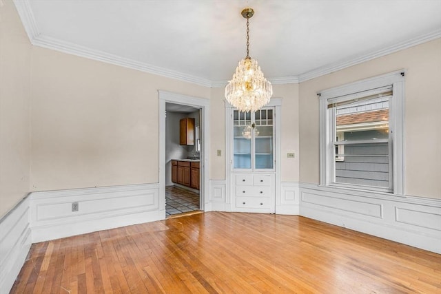 127-129 Blue Hills Pkwy, Milton, MA 02186 - empty room with a chandelier, ornamental molding, wood-type flooring, wainscoting, and a decorative wall