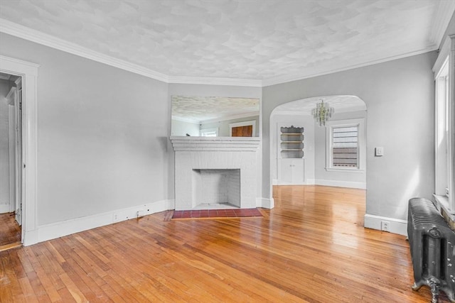 127-129 Blue Hills Pkwy, Milton, MA 02186 - unfurnished living room with radiator, hardwood / wood-style floors, arched walkways, healthy amount of natural light, and ornamental molding