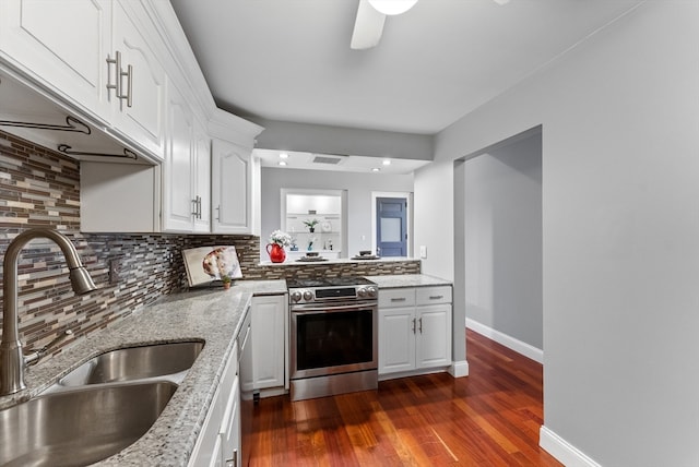 kitchen with decorative backsplash, dark hardwood / wood-style flooring, stainless steel range, sink, and white cabinetry