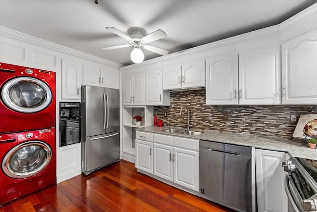 kitchen featuring appliances with stainless steel finishes, dark wood-type flooring, sink, white cabinetry, and stacked washer / drying machine