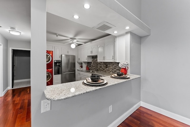 kitchen with white cabinetry, decorative backsplash, stainless steel fridge, and dark hardwood / wood-style flooring