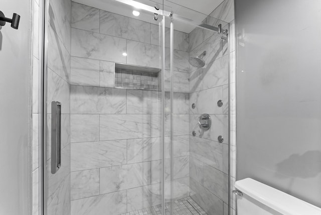 bathroom with toilet and an enclosed shower