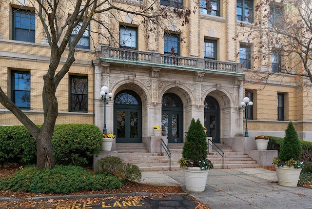 view of exterior entry with french doors and a balcony