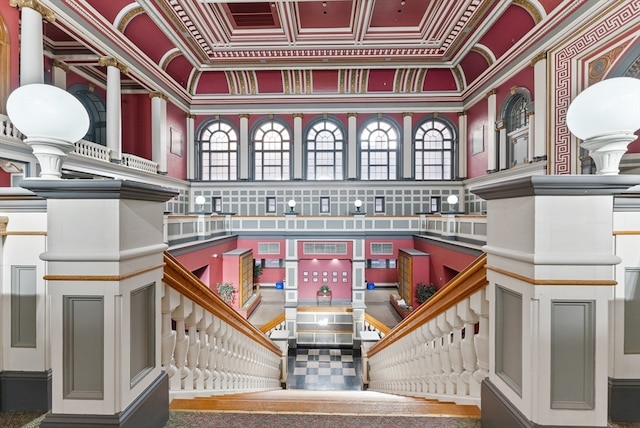 interior space with decorative columns, crown molding, and a towering ceiling