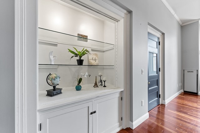 bar with crown molding, white cabinets, and dark hardwood / wood-style floors