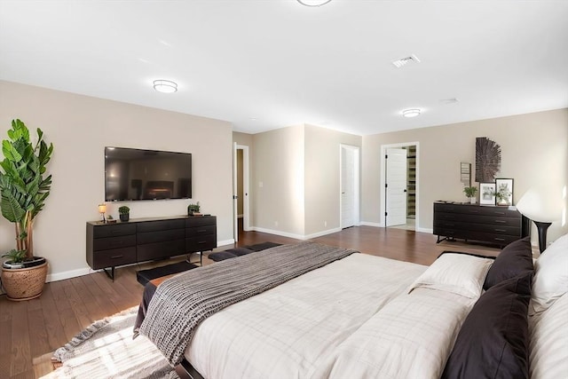 bedroom featuring visible vents, baseboards, and wood finished floors