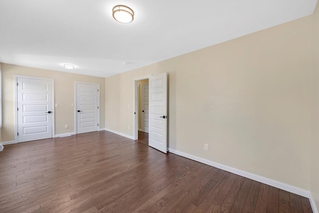 unfurnished bedroom featuring dark wood finished floors and baseboards