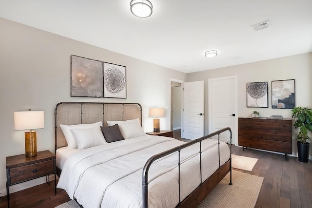 bedroom with dark wood-style floors and visible vents