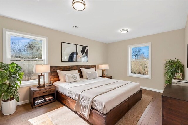 bedroom with visible vents, wood-type flooring, and baseboards