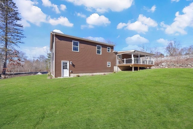 back of house featuring a lawn and a deck