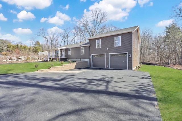 tri-level home featuring a garage, a front lawn, and driveway