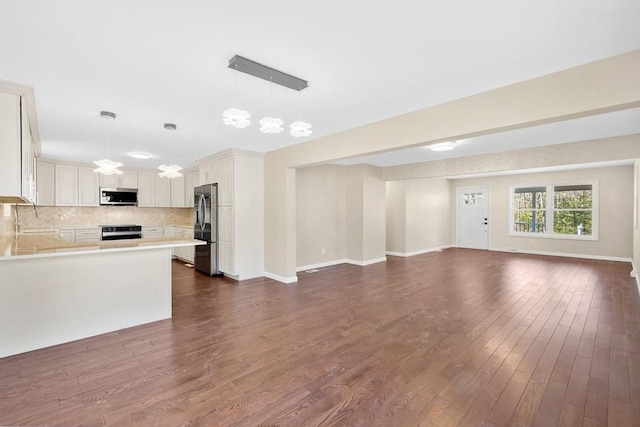 unfurnished living room featuring baseboards and dark wood finished floors