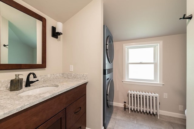203 State St, Northampton, MA 01060 - bathroom with radiator heating unit, stacked washer / dryer, vanity, vaulted ceiling, and baseboards
