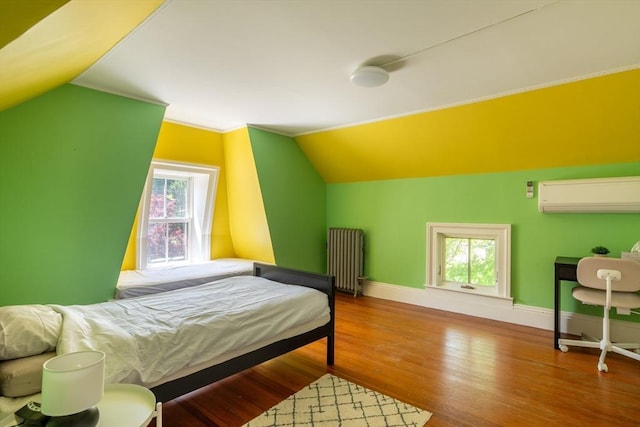203 State St, Northampton, MA 01060 - bedroom with radiator, a wall unit AC, lofted ceiling, baseboards, and wood finished floors