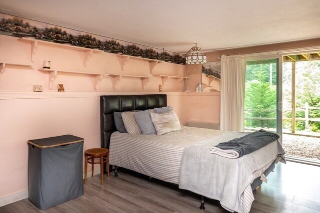 bedroom with dark hardwood / wood-style floors and access to outside