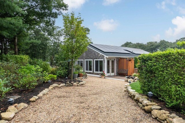 rear view of property with solar panels