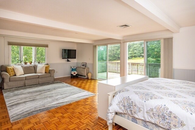 bedroom with dark parquet floors, beam ceiling, and access to outside