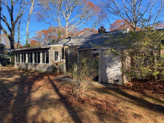 rear view of house featuring a sunroom