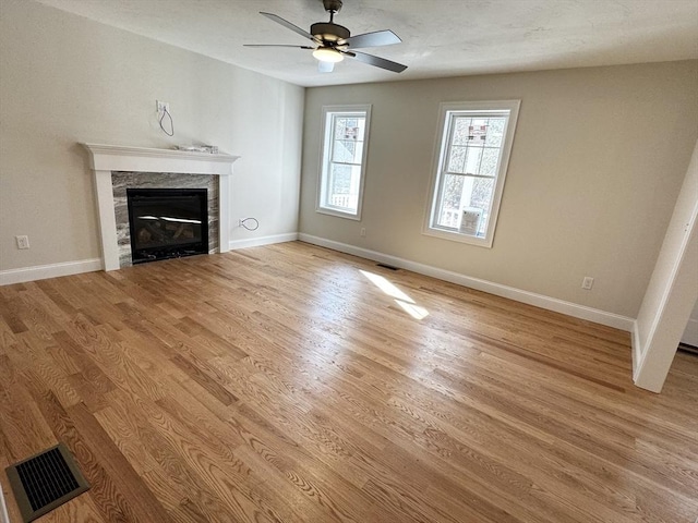 unfurnished living room featuring ceiling fan and light hardwood / wood-style flooring