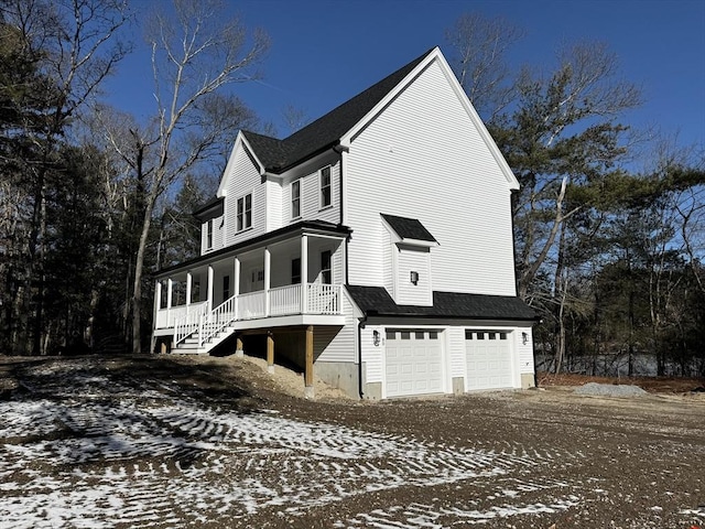 view of snow covered exterior featuring a garage and covered porch