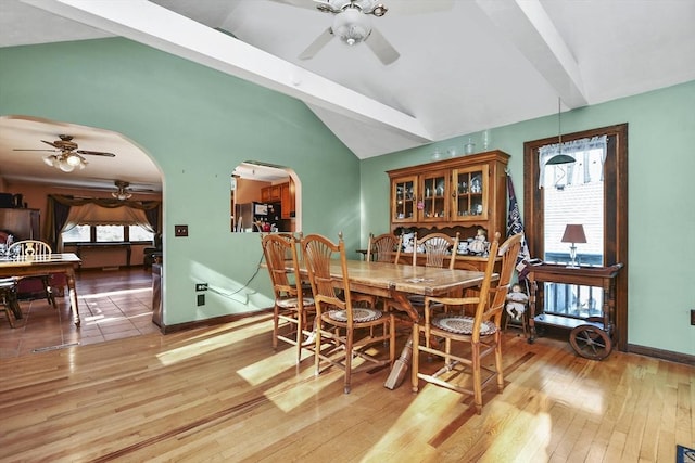 dining room with hardwood / wood-style floors, a wealth of natural light, and lofted ceiling with beams