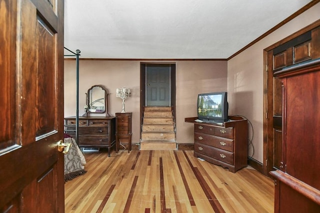 bedroom with ornamental molding and light hardwood / wood-style flooring