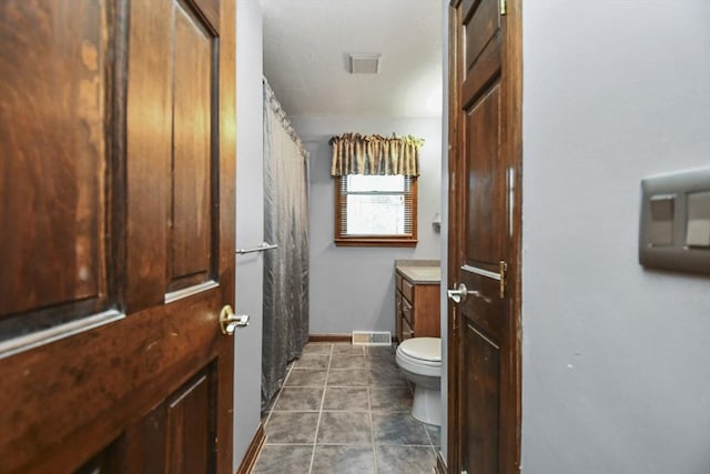 bathroom with vanity, tile patterned floors, and toilet