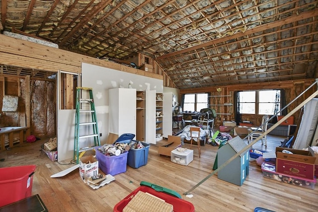 miscellaneous room featuring wood-type flooring and vaulted ceiling