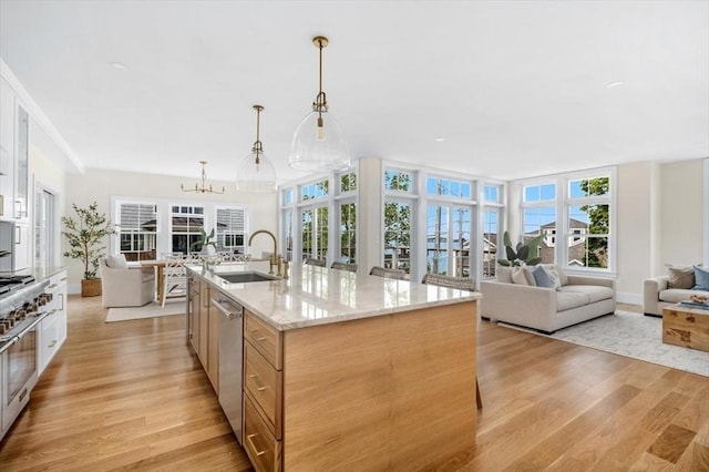 34 Otis Hill Rd, Hingham, MA 02043 - kitchen with open floor plan, a sink, stainless steel dishwasher, light wood-style flooring, and light stone countertops