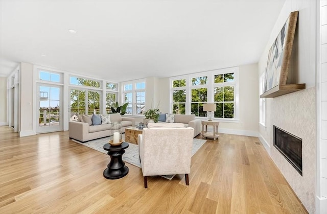 34 Otis Hill Rd, Hingham, MA 02043 - living area with light wood-type flooring, a glass covered fireplace, and baseboards