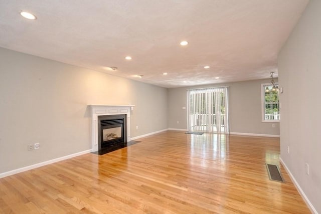2 Dalton Ter, Holbrook, MA 02343 - unfurnished living room with recessed lighting, light wood-style floors, a fireplace with flush hearth, and a chandelier
