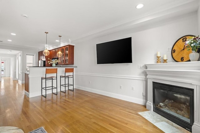 53 Woodward St Unit 2, Boston, MA 02127 - living area with light wood-style floors, recessed lighting, ornamental molding, a fireplace with flush hearth, and baseboards