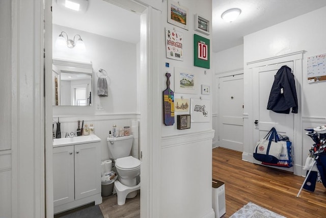 bathroom with vanity, wood finished floors, and toilet