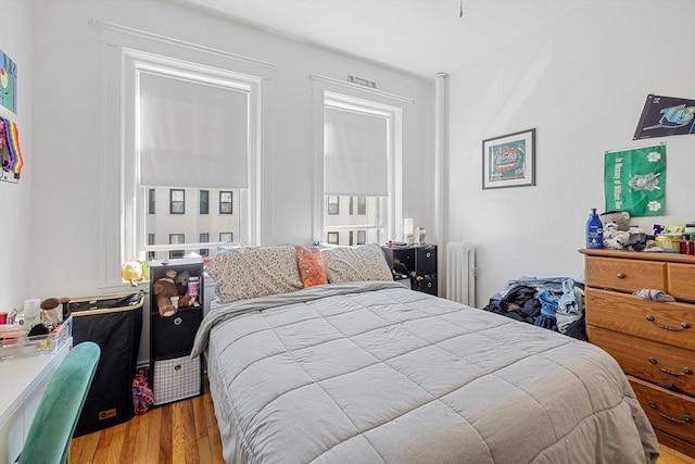 bedroom featuring radiator heating unit and wood finished floors